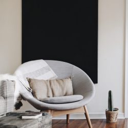 round grey moon chair with brown pillow on top